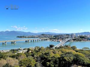 a bridge over a river with a city in the background at Central Park Flat Residence - Home Time in Florianópolis