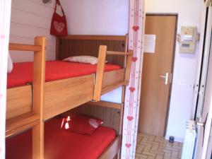 シャテルにあるStudio Châtel, 1 pièce, 3 personnes - FR-1-200-157の赤いマットレス付きの二段ベッド2台が備わる客室です。