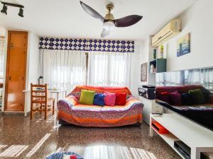 een woonkamer met een bank en kleurrijke kussens bij Piso ideal con WIFI Parking y Desayuno in Murcia