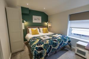 a bedroom with a bed and a green wall at The Hive Apartment in Marple