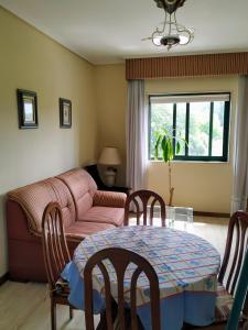 sala de estar con mesa y sofá en Apartamento Samil Primera Línea de Playa 3O, en Vigo