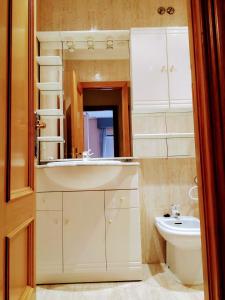 y baño con lavabo, aseo y espejo. en Apartamento Samil Primera Línea de Playa 3O, en Vigo