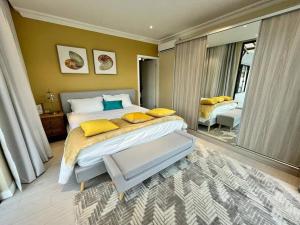 - une chambre avec un grand lit et des oreillers jaunes dans l'établissement Rich villa is new, stunning and modern, à Calodyne