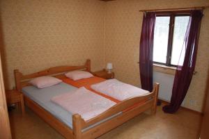 una camera da letto con un letto con due cuscini e una finestra di Nice house with new bathroom, good accessibility 
