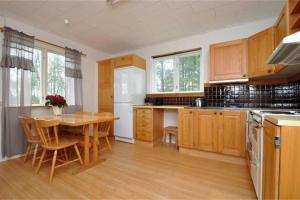 cocina con armarios de madera y mesa de madera en Nice house with new bathroom, good accessibility, 