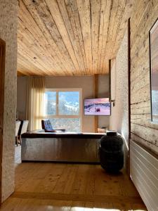 uma sala de estar com um sofá e uma grande janela em WOO® Loft Resort em Fiesch