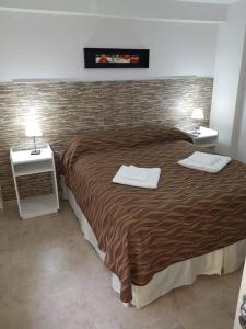 1 dormitorio con 1 cama grande y 2 mesitas de noche en Piscis II en Córdoba