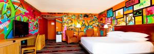 a hotel room with a bed and a colorful wall at Nativo Lodge in Albuquerque