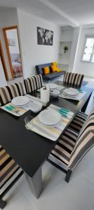 a black dining room table with chairs and plates on it at Xalpen Ushuaia in Ushuaia