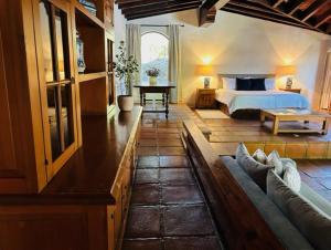 een slaapkamer met een bed en een bank in een kamer bij Villa Tatala hotel boutique in Tepoztlán