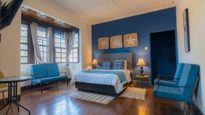 a bedroom with blue walls and a bed and blue chairs at Finca Escalante in San José