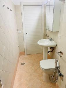 ein Badezimmer mit einem Waschbecken, einem WC und einem Spiegel in der Unterkunft Napoli Forcella House al centro di Napoli in Neapel