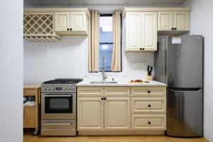 a kitchen with white cabinets and a stainless steel refrigerator at 454-4R New 2BR prime midtown Best value Sleeps 5 in New York