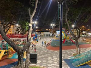una zona de juegos en un parque por la noche con gente en Encantador departamento en Garzota, en Guayaquil