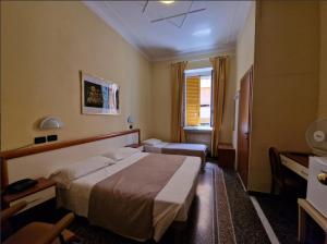 een hotelkamer met een bed en een bureau bij Albergo Boccadasse in Genua