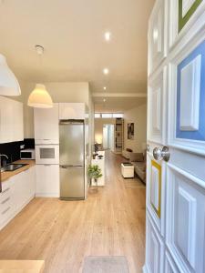 a kitchen with white cabinets and a refrigerator at El Apartamento de Trini en la Alameda in Seville