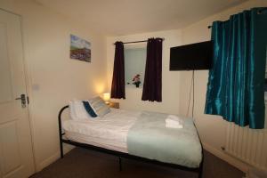 a small bedroom with a bed and a window at Stirling House in Sheffield