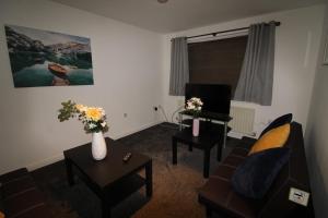 a living room with a couch and a table with flowers at Stirling House Sheffield by Smart Corporate Stays in Sheffield