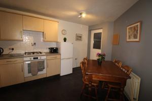 a kitchen with a table and a white refrigerator at Stirling House Sheffield by Smart Corporate Stays in Sheffield