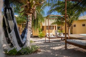 a resort with a hammock and two palm trees at Beekite Wind Village in Luis Correia