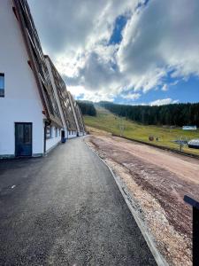 an empty road in front of a white building at Apartman Maksim Ravna Planina in Pale