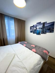 a bedroom with a bed with two pictures on the wall at Apartman Maksim Ravna Planina in Pale