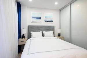 1 dormitorio con 1 cama blanca grande y 2 mesitas de noche en 75-1A NEW Prime UES W D in unit Elevator, en Nueva York