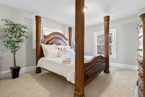1 dormitorio con cama grande de madera y espejo en Cozy 4B Retreat Near Uptown King Beds Sleeps 12 en Charlotte