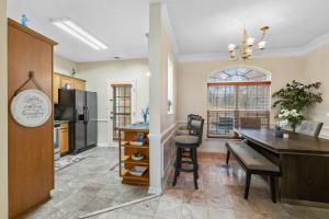 a kitchen and dining room with a table and a refrigerator at Cozy 4B 2 5B University Home King Beds Jacuzzi in Charlotte
