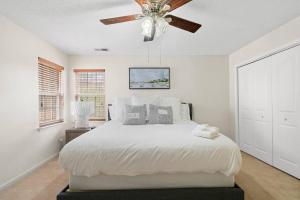 a bedroom with a bed with a ceiling fan at Cozy 4B 2 5B University Home King Beds Jacuzzi in Charlotte