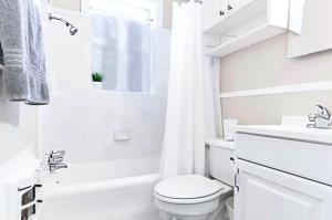 uma casa de banho branca com um WC e um lavatório em 1920s Urban Charm Aboretum Tickets Available em Dallas