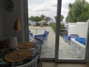 Cette chambre dispose d'une porte s'ouvrant sur une terrasse avec une table et des chaises. dans l'établissement Enigma Boutique Houses Ammos, à Marmarion