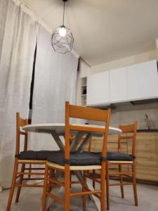 a table and chairs in a kitchen with aendant light at Rifugio in città in Modena