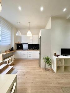 an open kitchen with white cabinets and a table at El Apartamento de Trini en la Alameda in Seville +10 photos