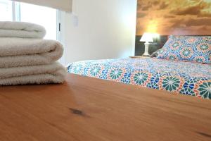 1 dormitorio con 1 cama y una pila de toallas en Piscis I en Córdoba