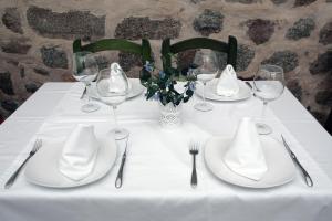 a table with white plates and silverware on it at Gran Hostal San Segundo in Ávila