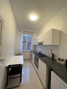 uma cozinha com armários brancos e uma bancada em Cosy Apartment Merode 2 em Bruxelas