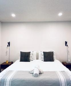 a bedroom with a large white bed with two pillows at 2-Bedroom Suite in the Heart of Downtown in Weyburn