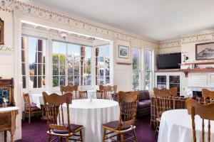 a dining room with tables and chairs and windows at Centrella Hotel, a Kirkwood Collection Hotel in Pacific Grove