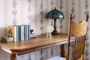 a wooden table with books and a lamp on it at Centrella Hotel, a Kirkwood Collection Hotel in Pacific Grove