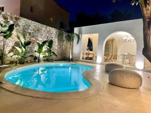a large swimming pool in a backyard at night at Byblos Aria-The Sea Side Luxury Villa in Skala Sotiros