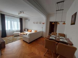 ein Wohnzimmer mit einem weißen Sofa und einem Tisch in der Unterkunft Apartmán Merry (9) in Bratislava