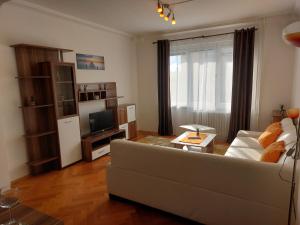 ein Wohnzimmer mit einem Sofa und einem TV in der Unterkunft Apartmán Merry (9) in Bratislava