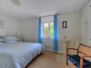 1 dormitorio con cama, lavabo y ventana en 30 Sherborne Lane, en Lyme Regis