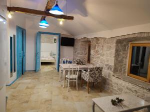 d'une salle à manger avec une table, des chaises et un mur en pierre. dans l'établissement Apartmani Pelješac Sova, à Sreser