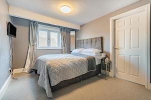 a bedroom with a bed and a window and a door at Chadbury House Annexe in Evesham
