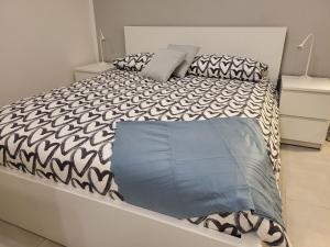 1 dormitorio con 1 cama con edredón blanco y negro en Rifugio in città, en Módena