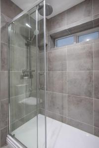 a shower with a glass door in a bathroom at Luxury, Sleeps 6, City Centre in Belfast