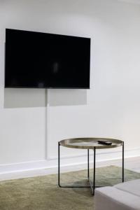a table in a room with a tv on a wall at Luxury, Sleeps 6, City Centre in Belfast