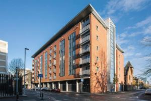 a large red brick building on a city street at Luxury, Sleeps 6, City Centre in Belfast